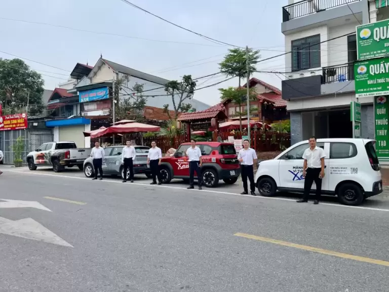 Đội ngũ tư vấn viên xếp hàng bên dàn xe điện VinFast sẵn sàng lái thử