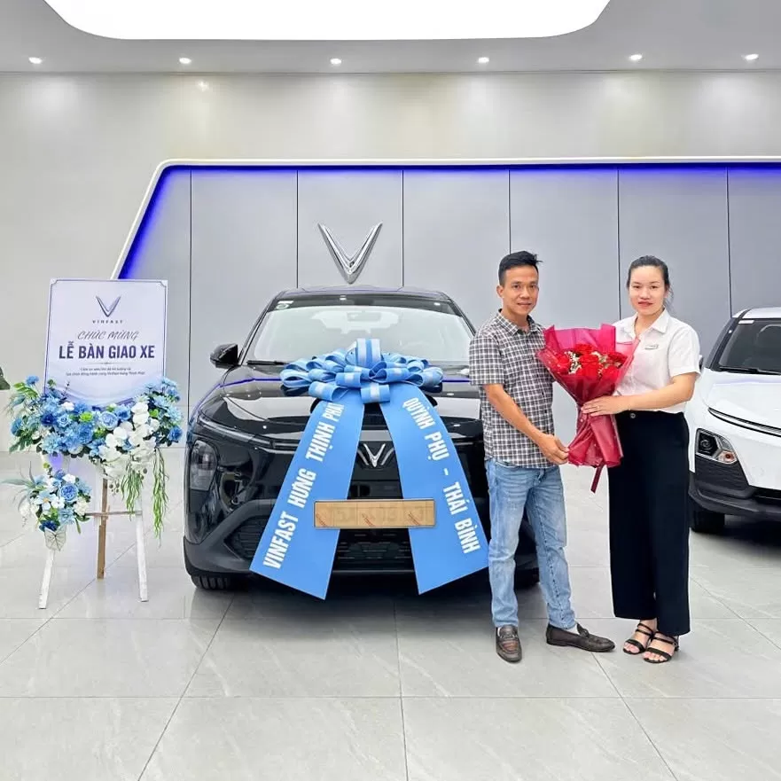 VinFast Hung Thinh Phat Ban Giao Xe Cho Khach Hang Tai Dai Ly Quynh Phu - VinFast tiếp tục dẫn đầu thị trường ô tô Việt Nam: Xe điện đang trở thành lựa chọn của nhiều khách hàng - VinFast Hưng Thịnh Phát Hình ảnh bàn giao xe ô tô điện VinFast màu đen đính nơ xanh