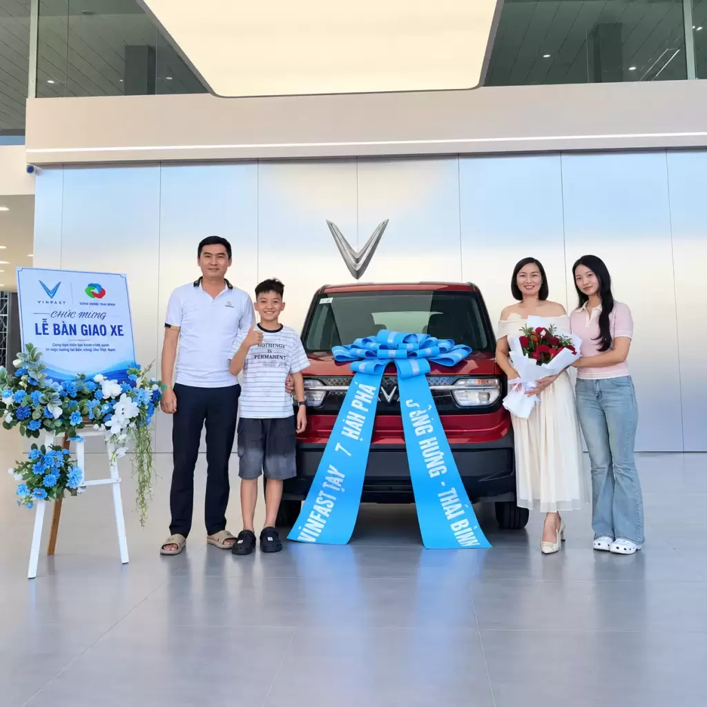 Nguyen Thi Thai VF3 - Khách hàng nhận xe tháng 9/2026 tại VinFast Hưng Thịnh Phát tại Hưng Thịnh Phát Gia đình khách hàng chụp ảnh kỷ niệm bên xe điện VinFast VF 3 màu đỏ