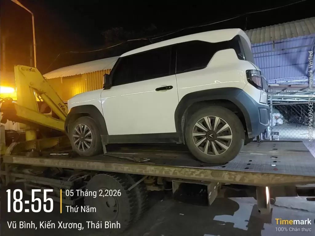 Xe điện VinFast VF 3 màu trắng nằm trên sàn xe cứu hộ