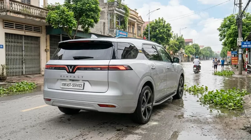 Xe Dien Vinfast Dung Truoc Duong Ngap 1 - Xe điện VinFast đi mưa, ngập nước: Cách xử lý an toàn tại Hưng Thịnh Phát Xe điện VinFast màu bạc đỗ bên đường gần đoạn đường ngập nước